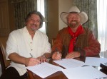 Sam Passamano of Rural Rhythm and Michael Martin Murphey sign a new contract during IBMA 2009